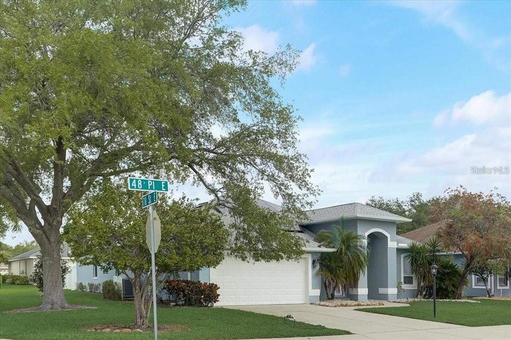 a view of a big house with a big yard and large trees