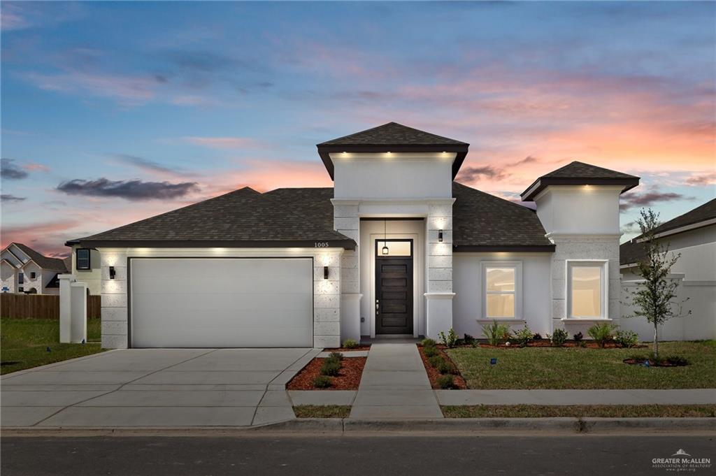 View of front of property with a yard and a garage