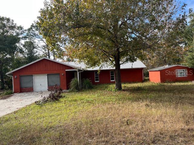 a small barn in front of a house with large trees