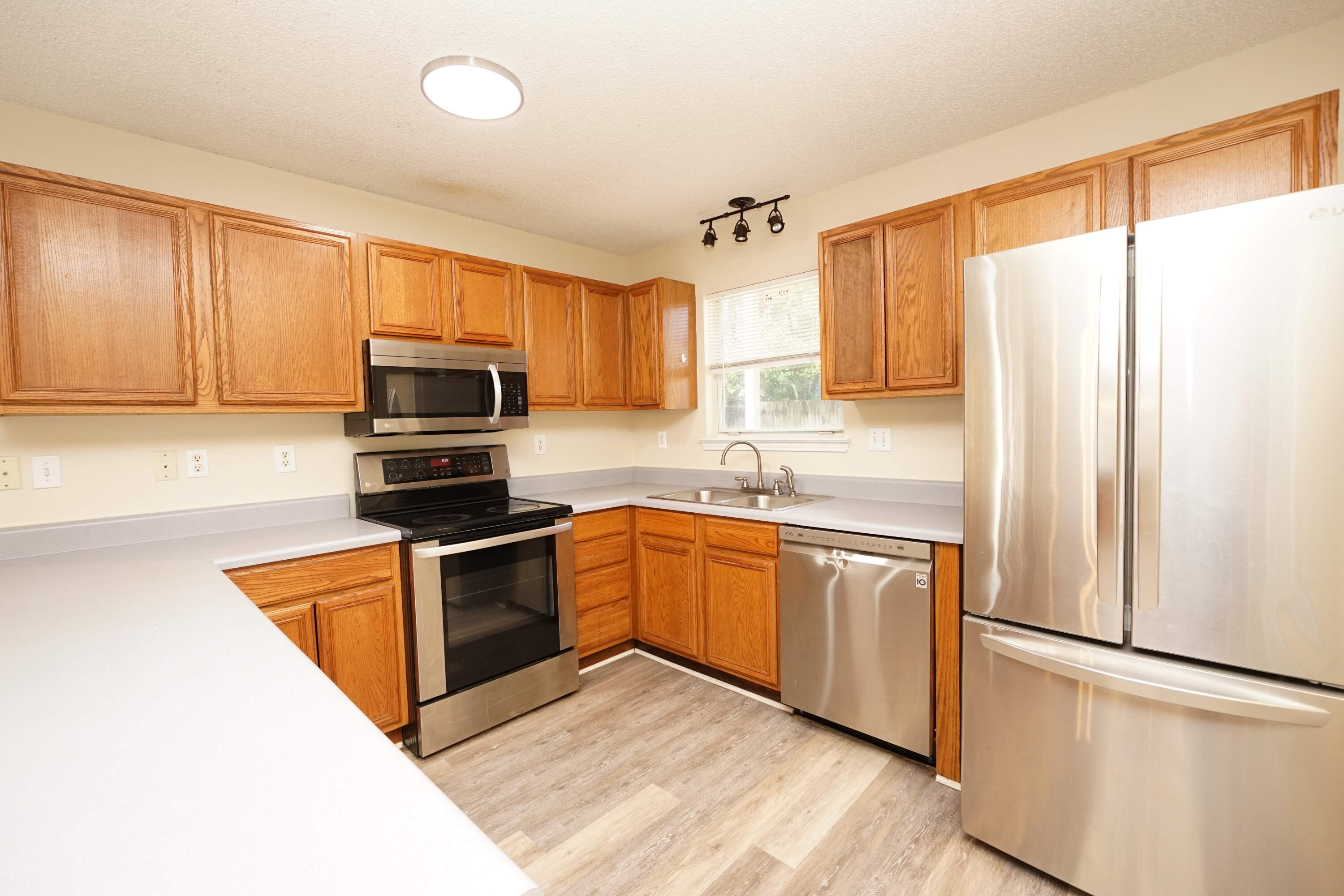 a kitchen with stainless steel appliances a refrigerator sink and microwave