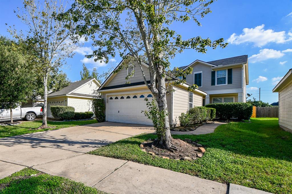 a front view of a house with a garden and tree