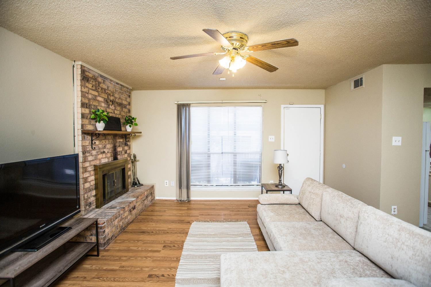 a living room with fireplace furniture and a flat screen tv