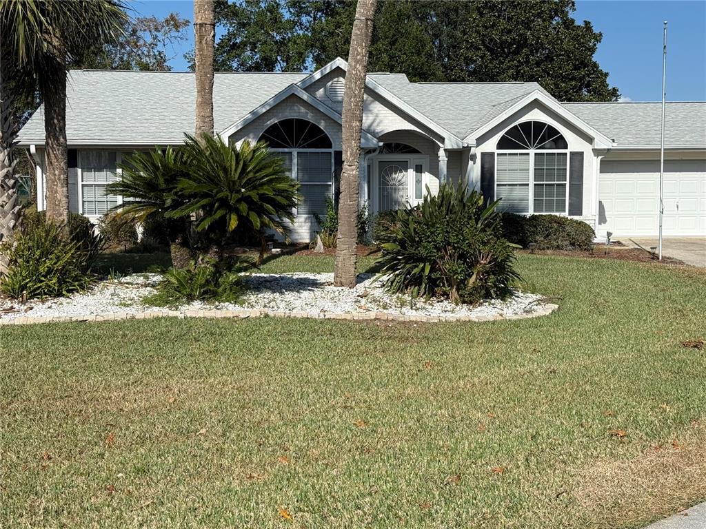 a front view of a house with a garden and yard