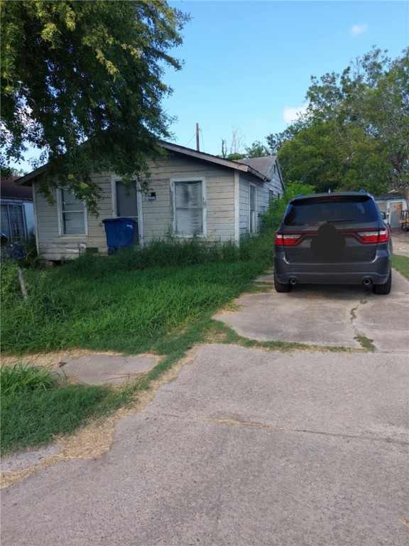 a view of a car parked in back yard of a house