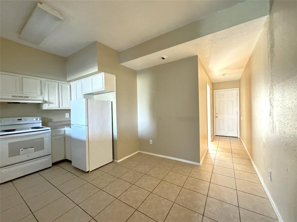 a kitchen with a stove top oven and cabinets