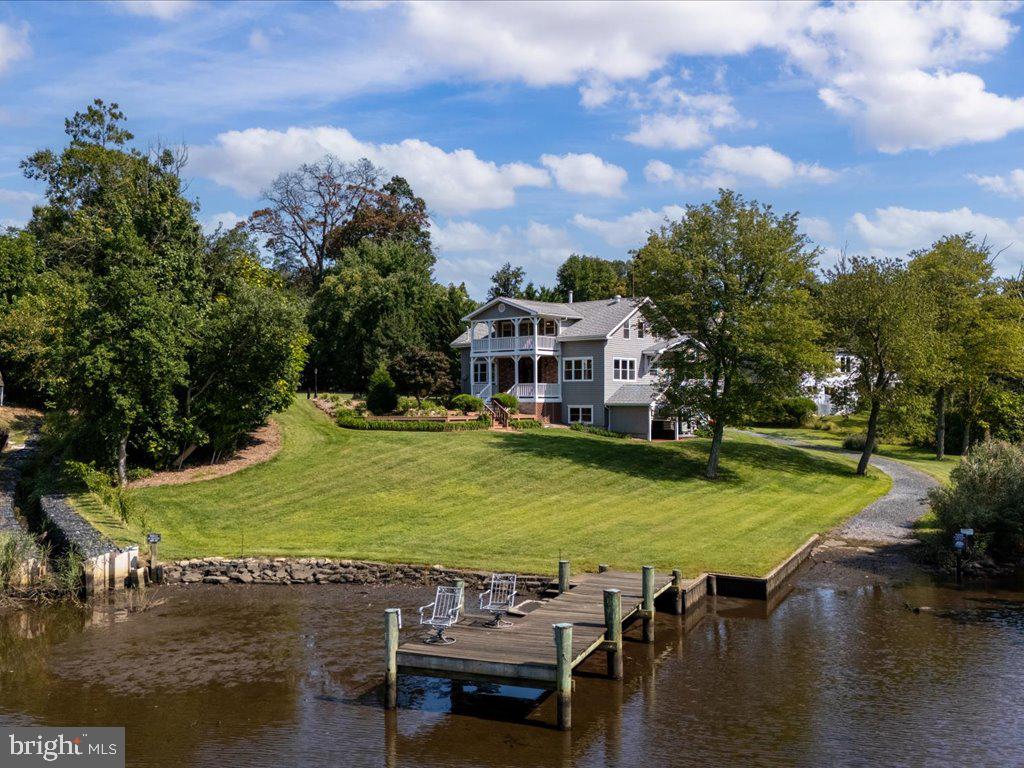 an aerial view of a house with swimming pool a yard and lake view