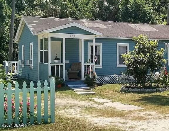 a front view of a house with a yard table and chairs