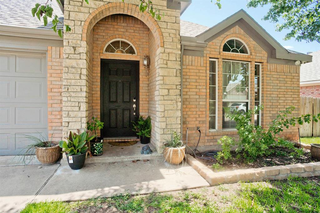 a view of a brick house with potted plants and a table