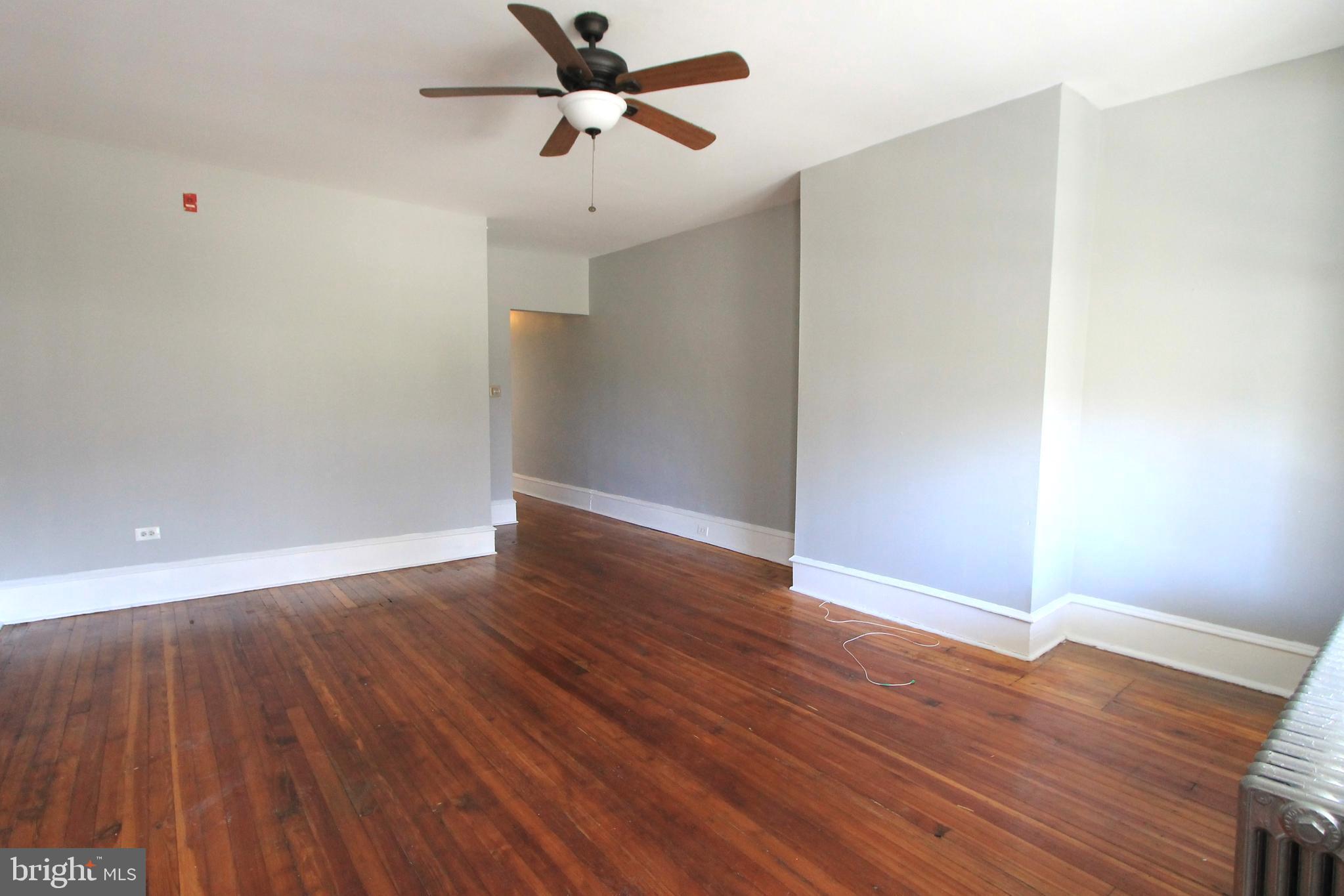 a view of empty room with wooden floor