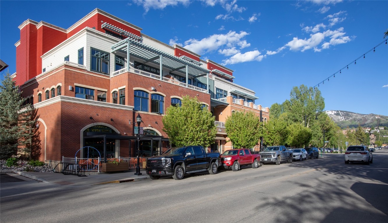 a front view of a building with parked cars