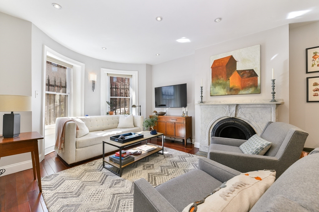 a living room with furniture a fireplace and a flat screen tv