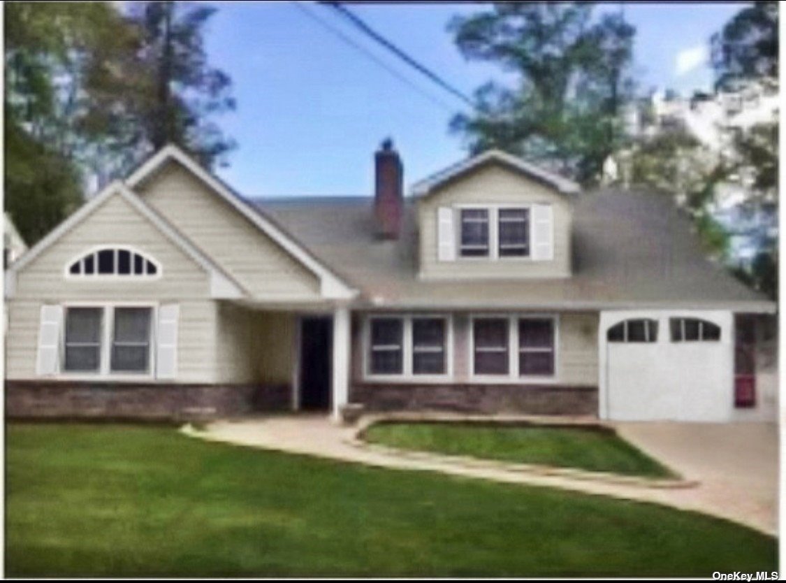 a front view of a house with a yard and trees