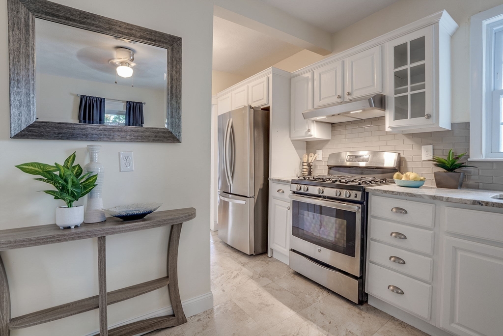 a kitchen with granite countertop a stove a sink and a refrigerator