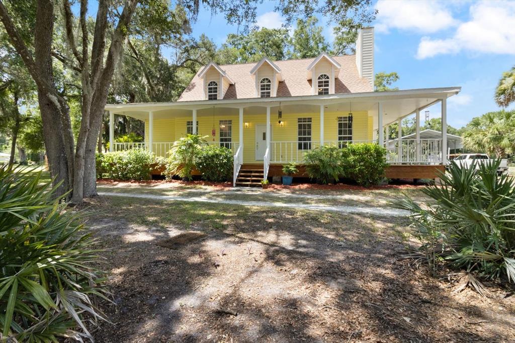 a front view of a house with a yard and potted plants