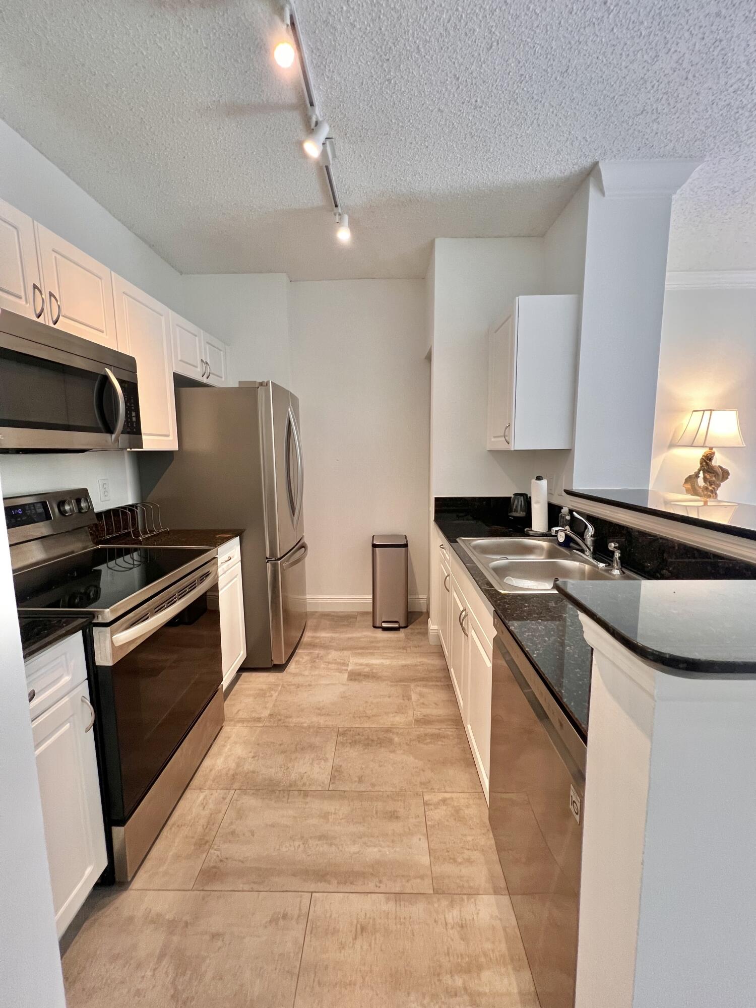 a large kitchen with kitchen island granite countertop a sink and stainless steel appliances