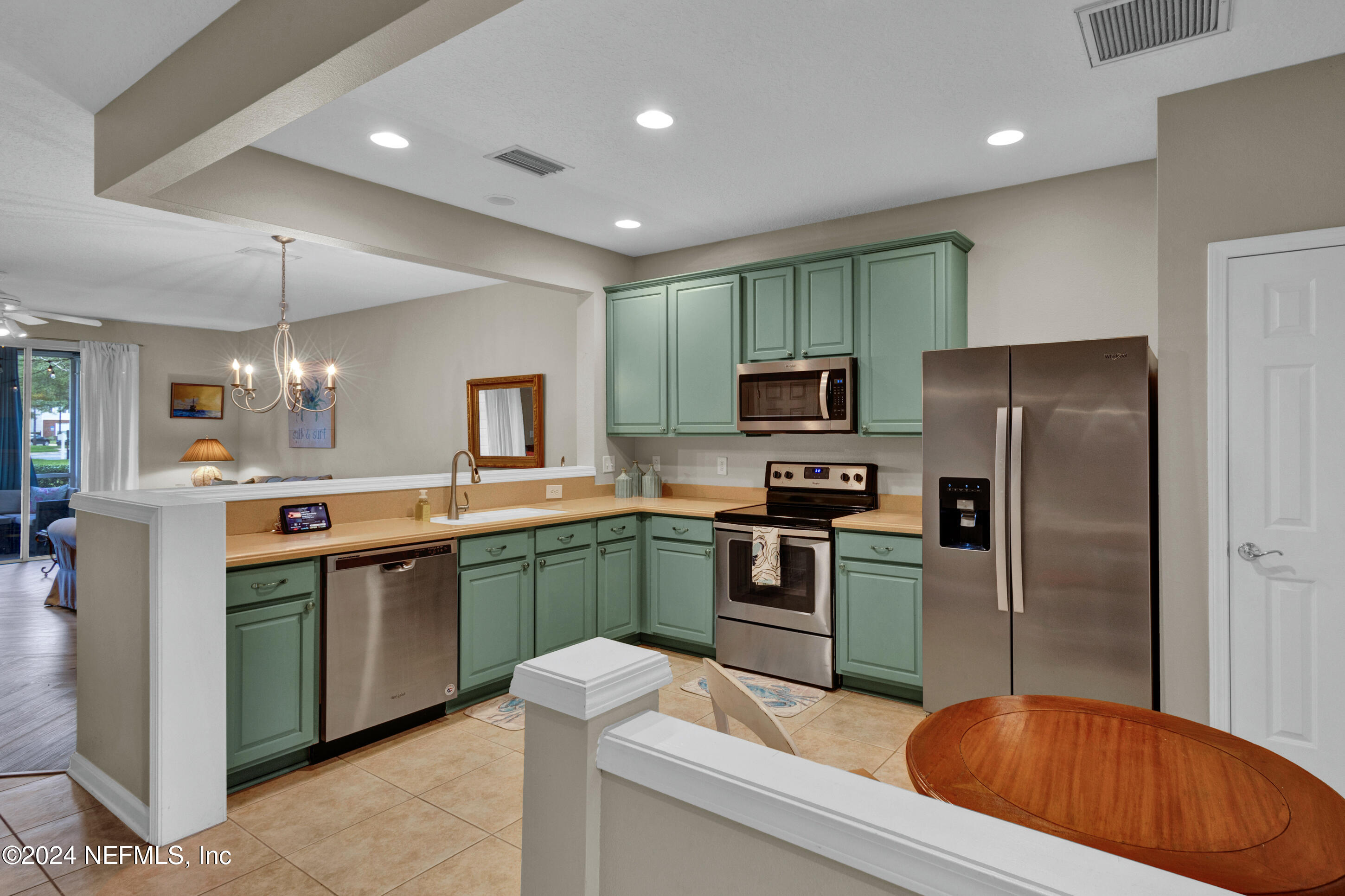 a kitchen with stainless steel appliances granite countertop a refrigerator a sink a stove a washer and a refrigerator