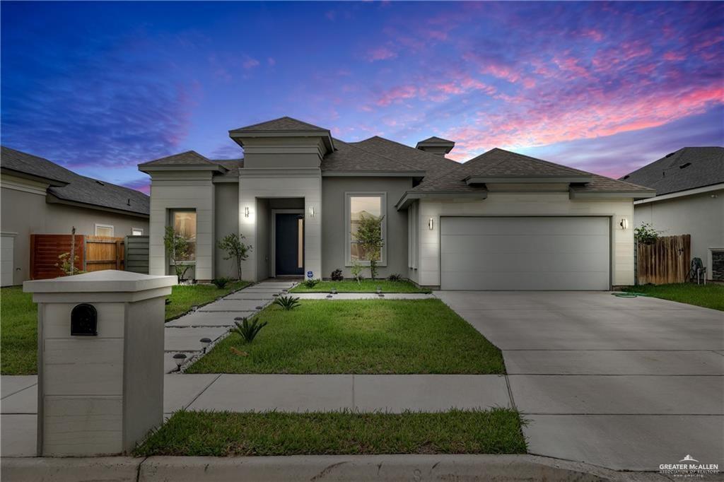 Prairie-style home featuring a garage and a lawn