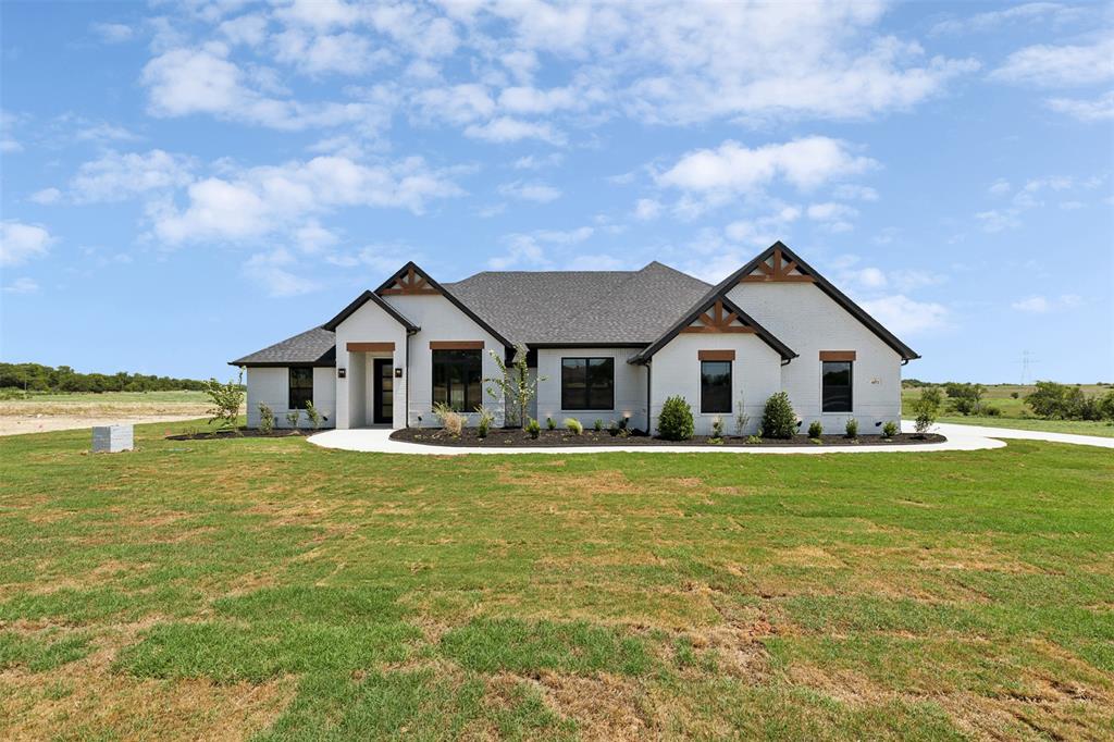 a aerial view of a house next to a big yard and large trees