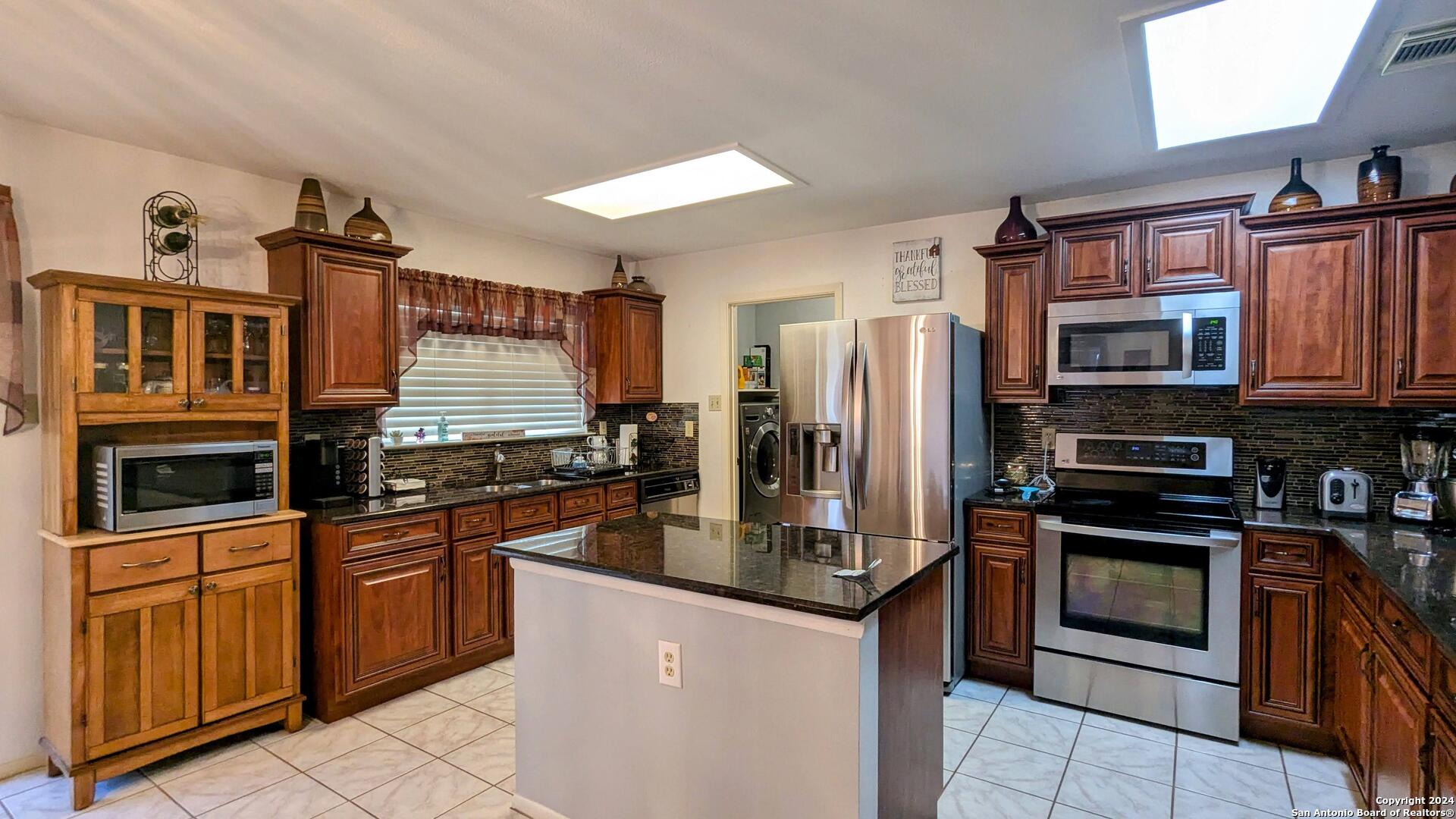 a kitchen with stainless steel appliances granite countertop a stove top oven a sink and dishwasher