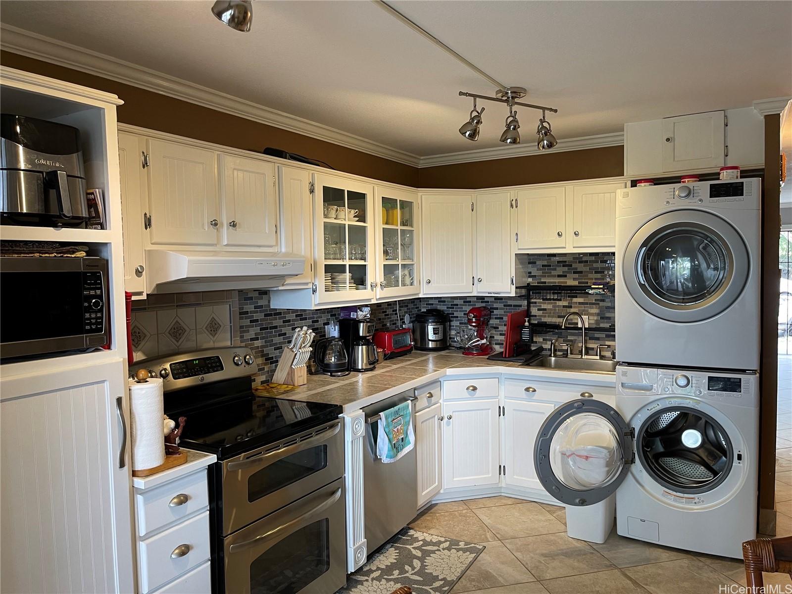 a kitchen with granite countertop a sink a stove and cabinets