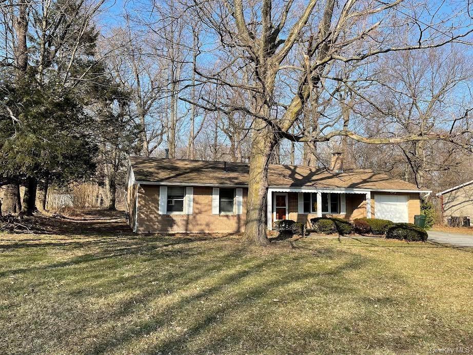 Single story home featuring a front lawn and a garage