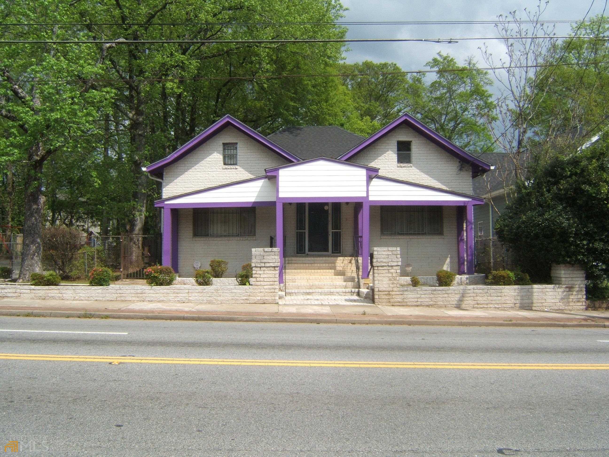 a view of a house with a yard and large tree