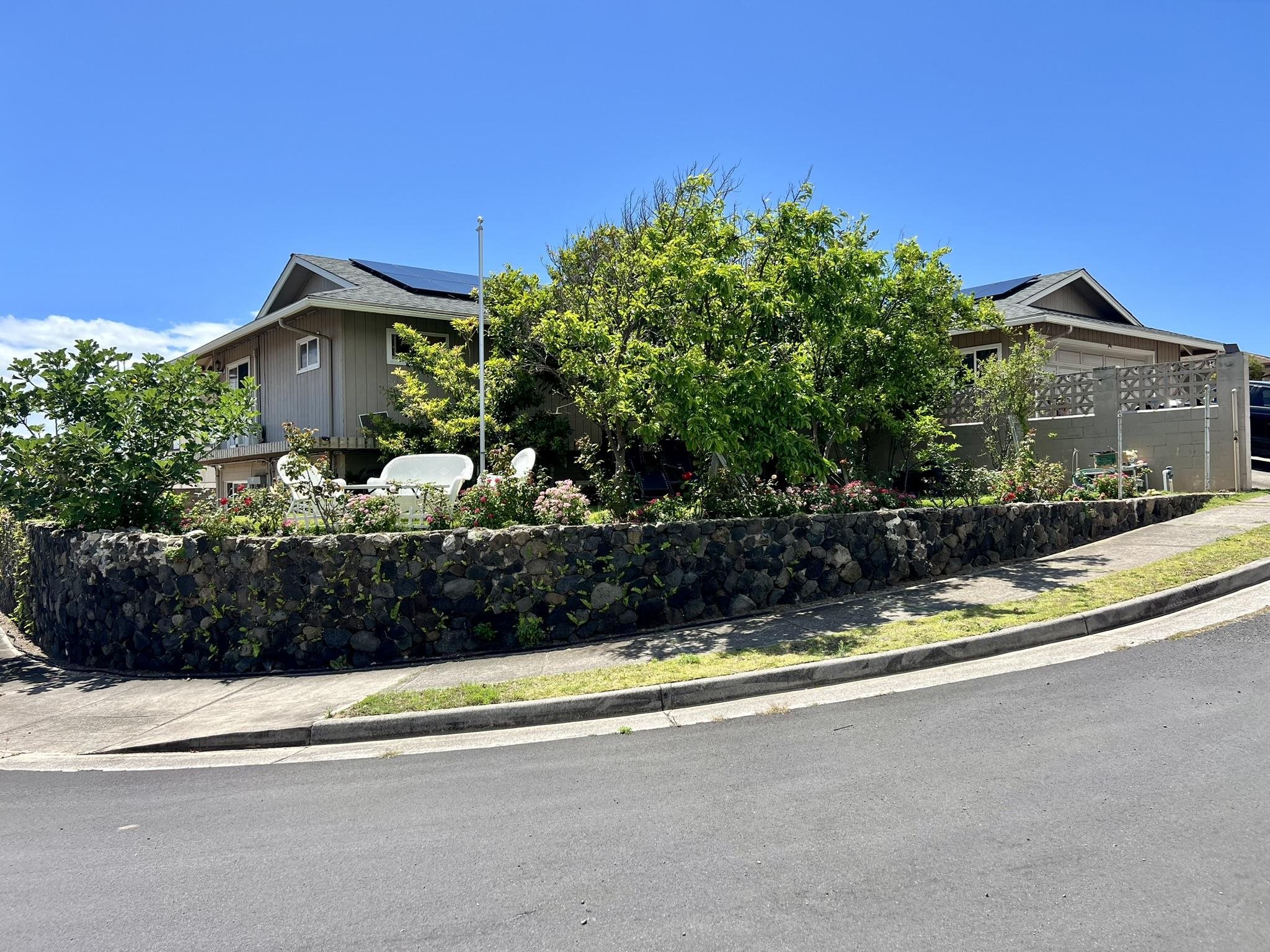 a view of a house with a small yard and potted plants