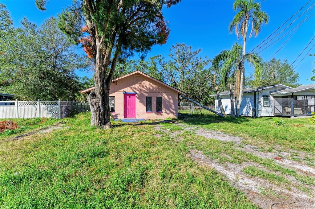 a view of a house with a yard and a tree