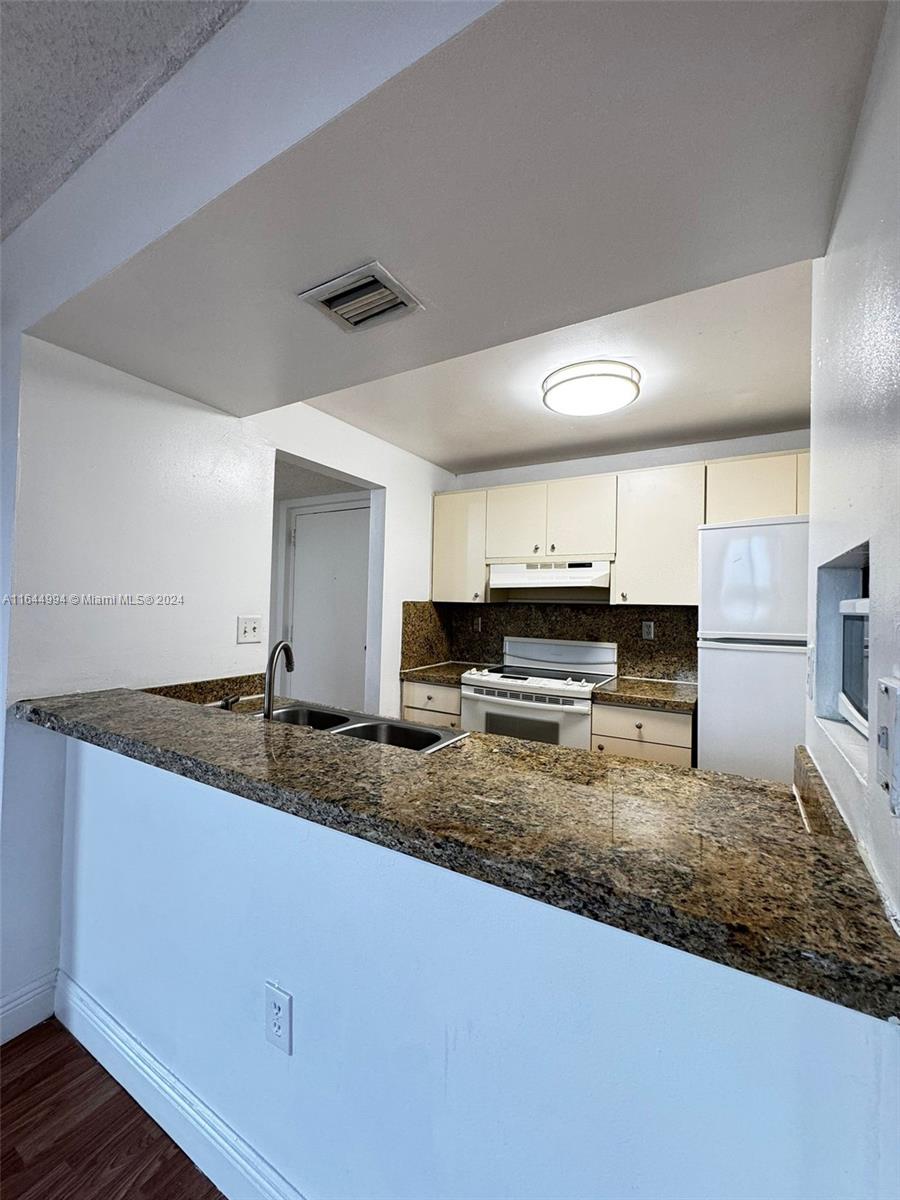 a kitchen with stainless steel appliances granite countertop a sink stove and cabinets