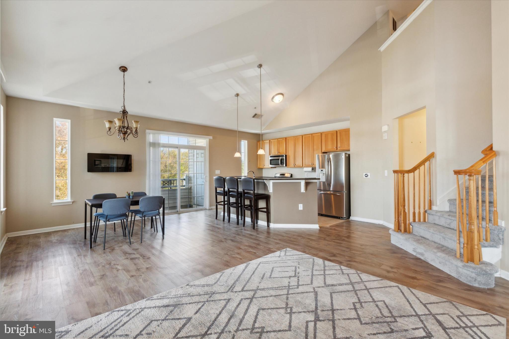 a view of a dining room and livingroom with furniture wooden floor a chandelier