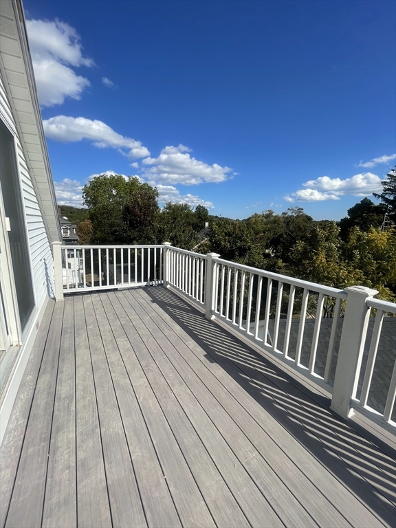 a view of balcony with wooden floor and fence