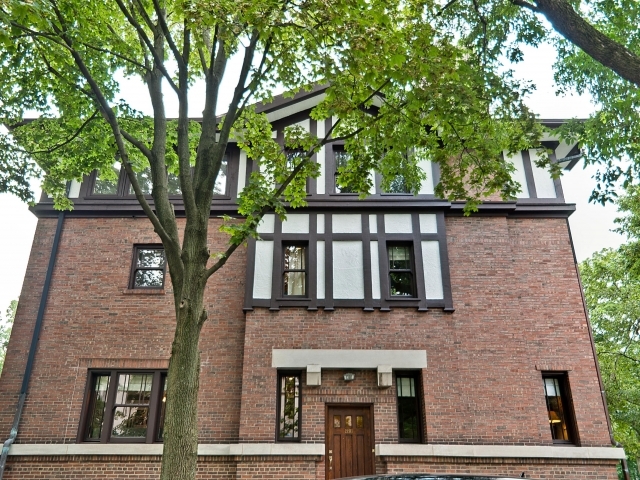 a front view of a house with a tree