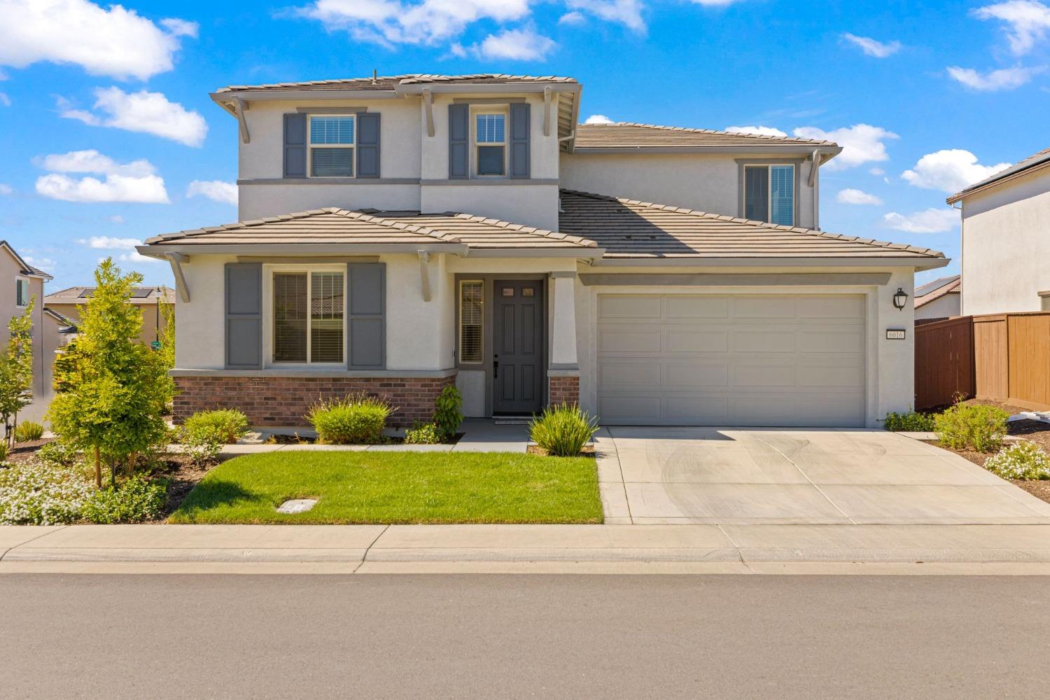 a front view of a house with a garden and yard