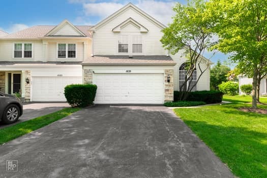 a view of house with a yard and a car parked in front of it