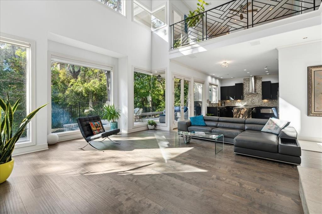 a living room with furniture a floor to ceiling window and potted plants