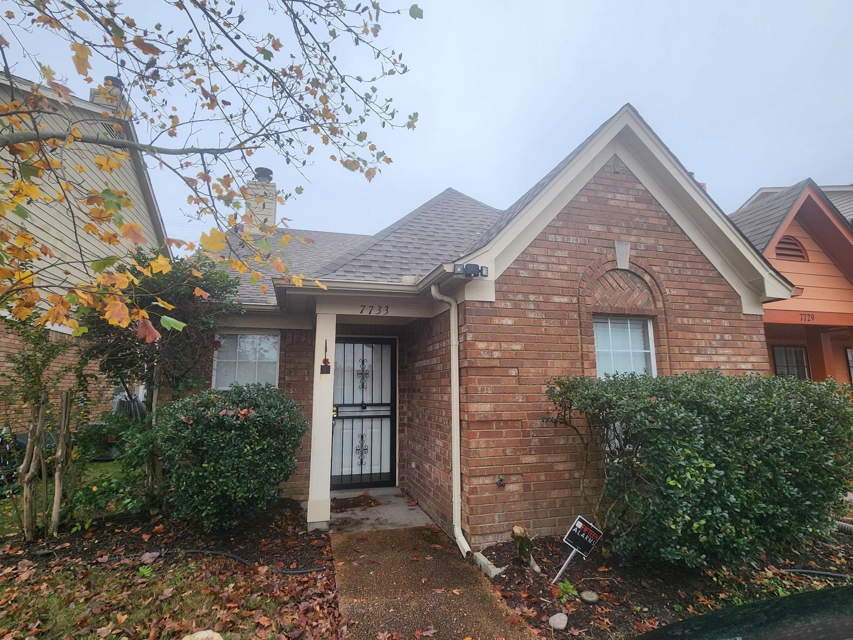 a view of a brick house next to a yard