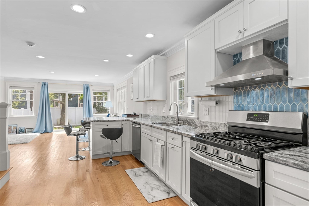 a kitchen with stainless steel appliances a stove a sink and cabinets