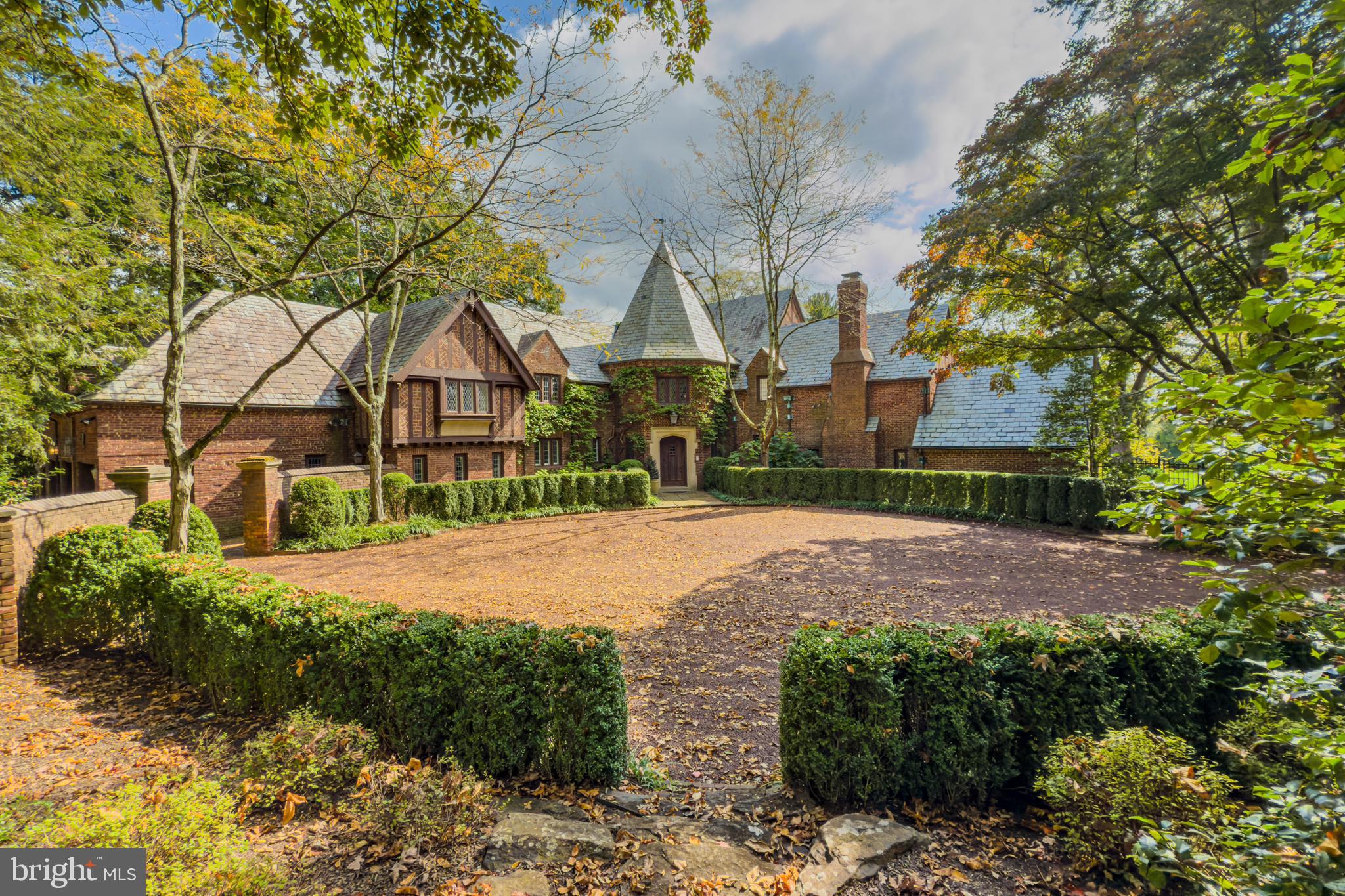 a front view of a house with a yard and large trees