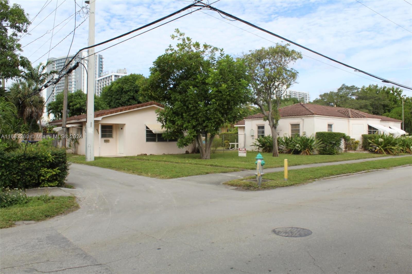 a view of a house with a big yard and potted plants