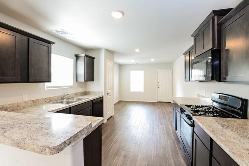 a kitchen with stainless steel appliances granite countertop hardwood floor sink stove and granite counter top