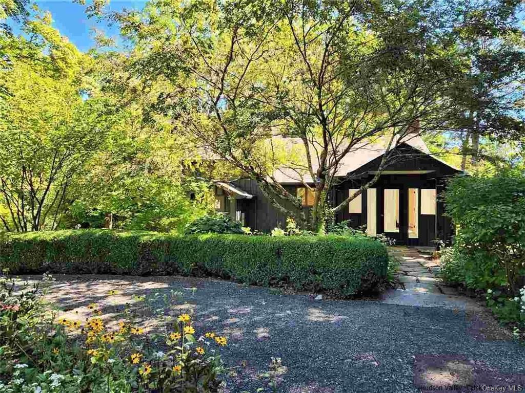 a front view of a house with a yard and shrubs