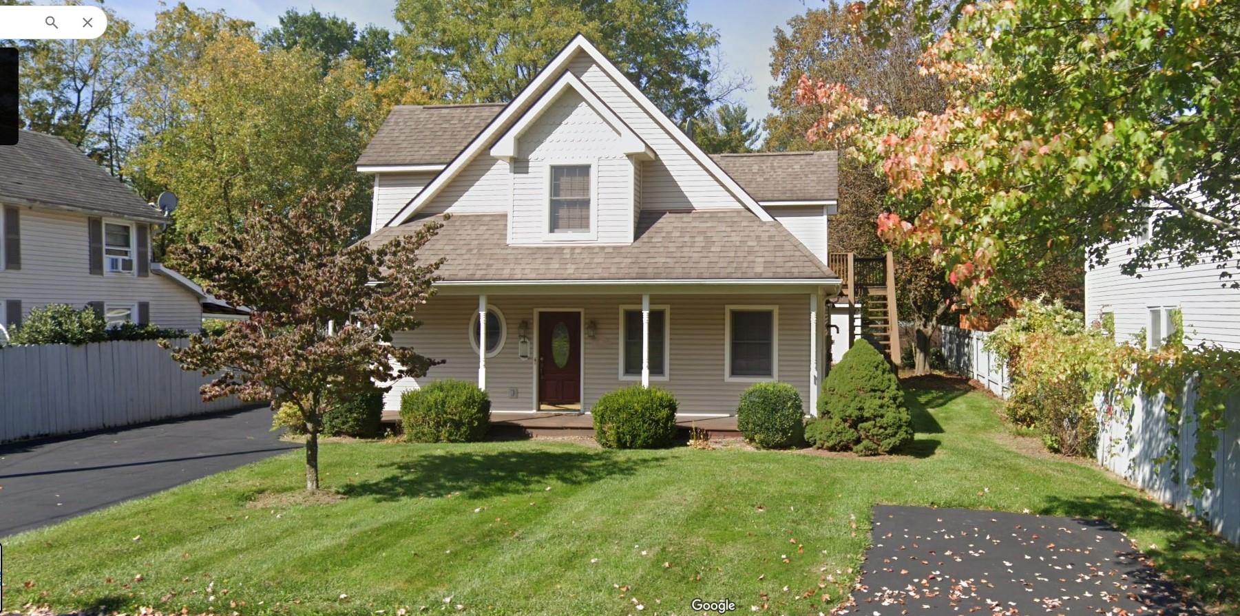 View of front of house with a porch and a front lawn