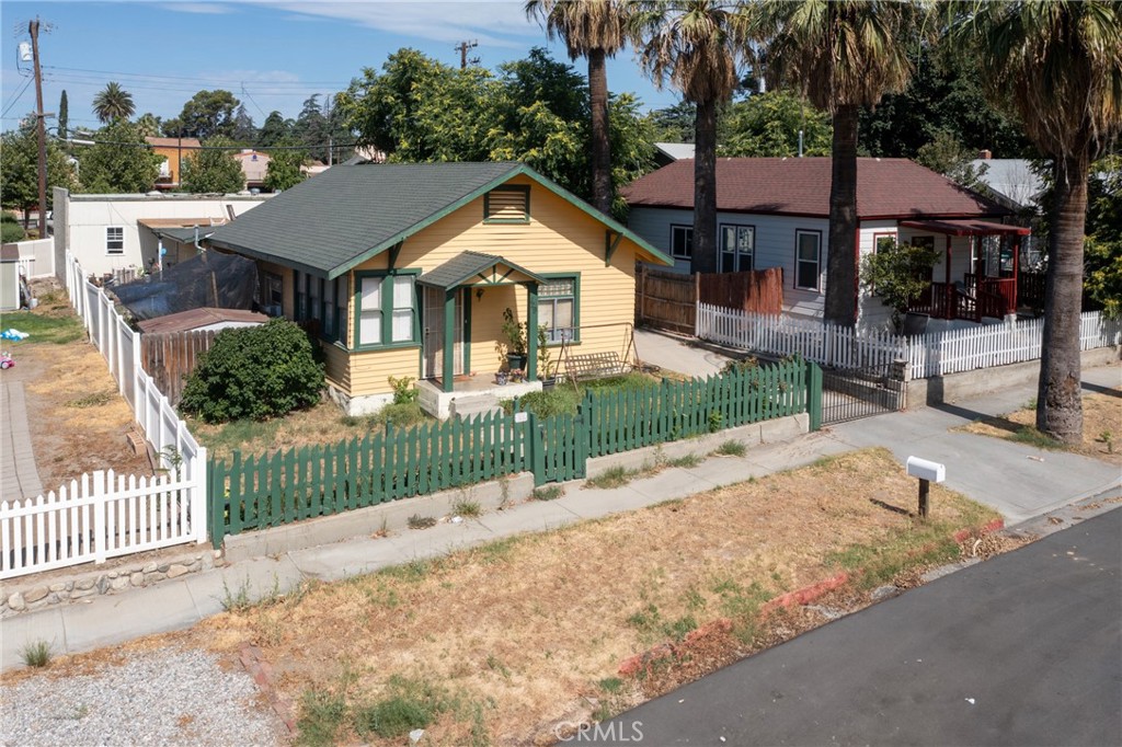 a front view of a house with a yard and potted plants