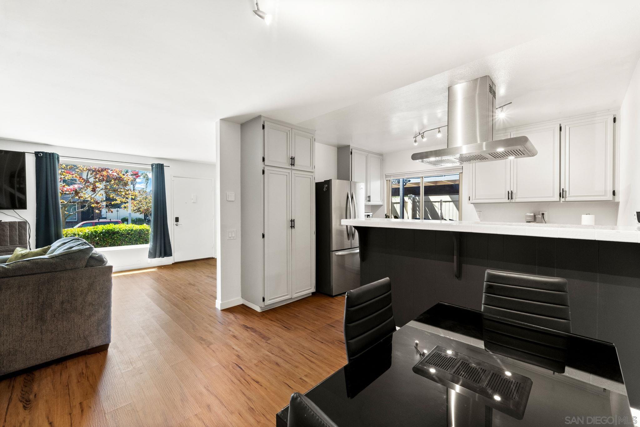 a living room with stainless steel appliances kitchen island granite countertop furniture a rug and a view of kitchen