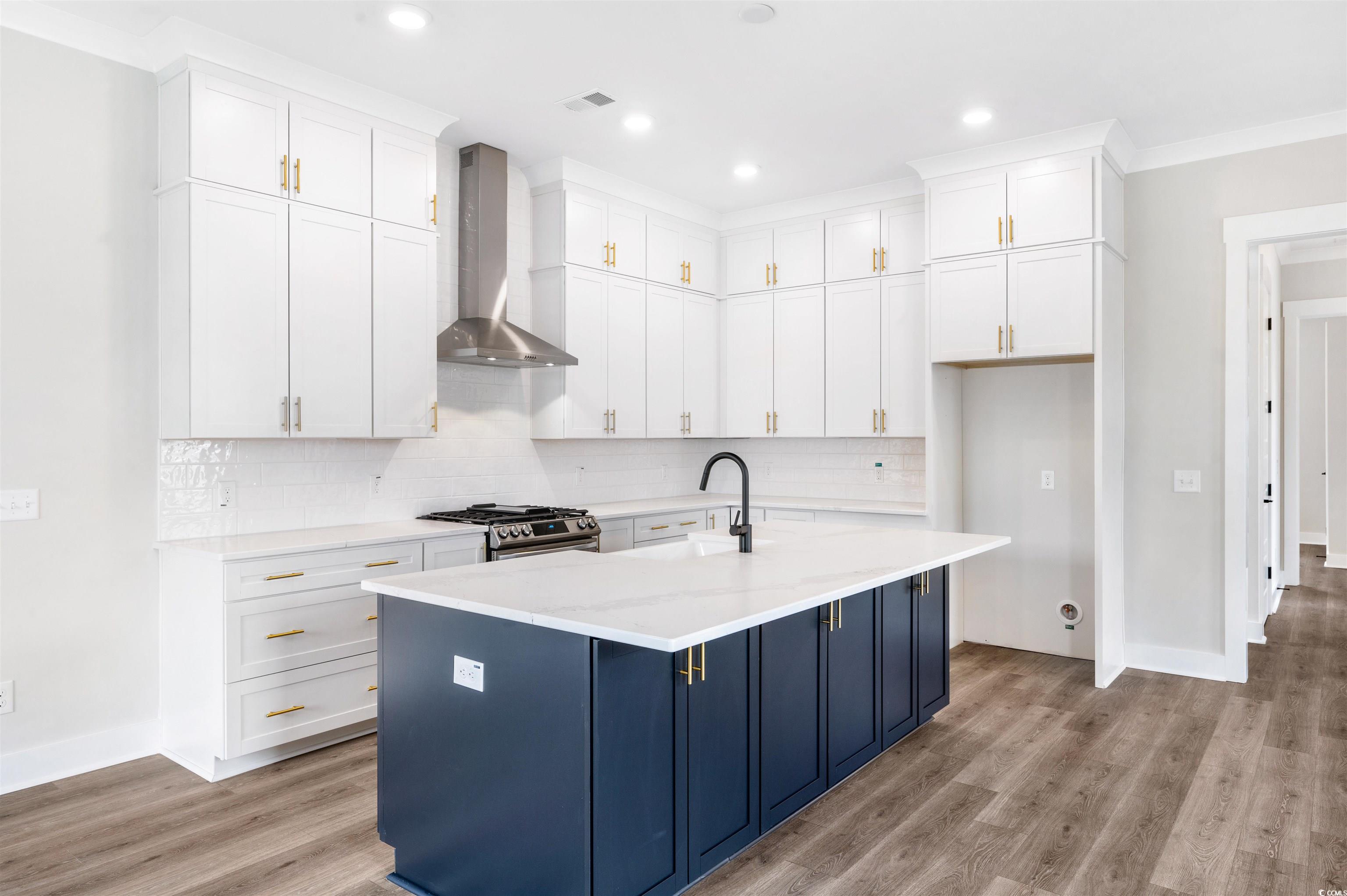 Kitchen featuring wall chimney range hood, stainle