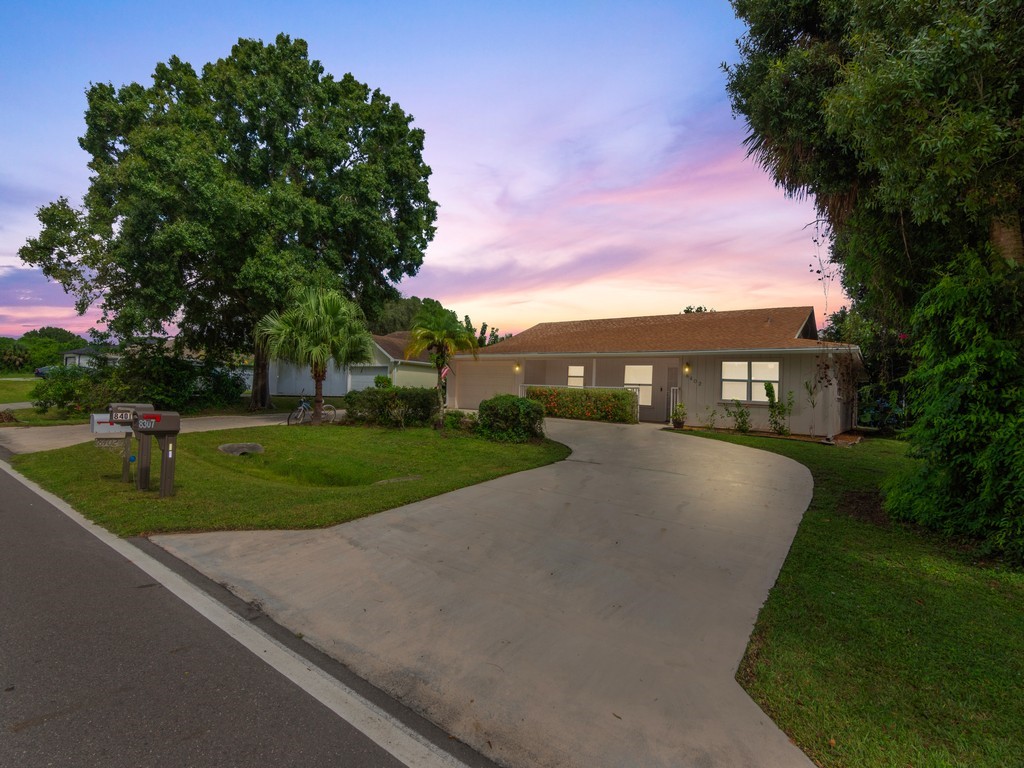 a view of a house with a yard and a street