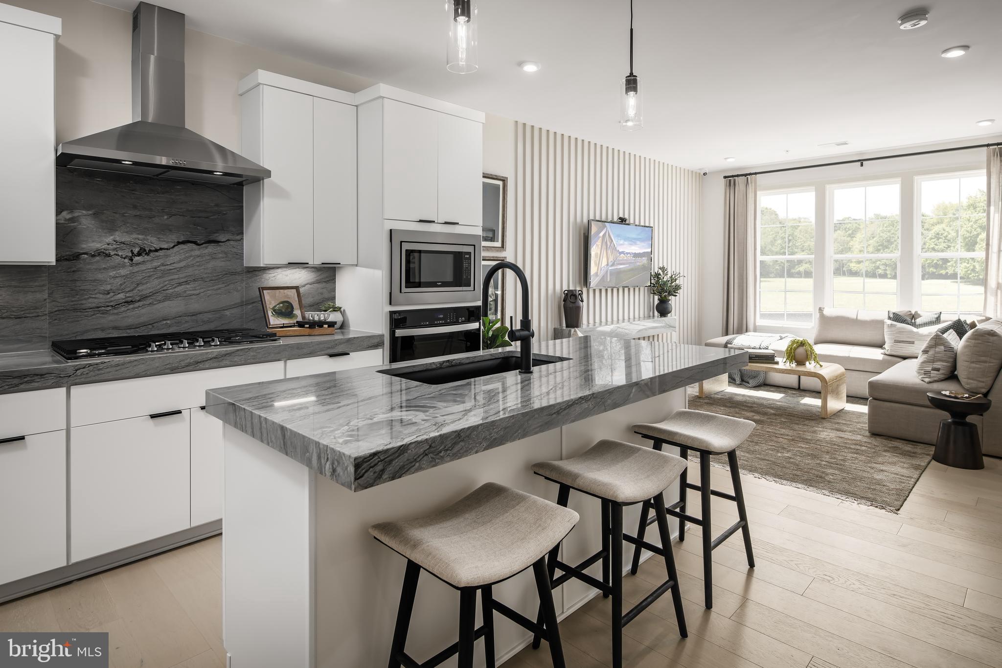 a kitchen with granite countertop a stove a sink a dining table and chairs