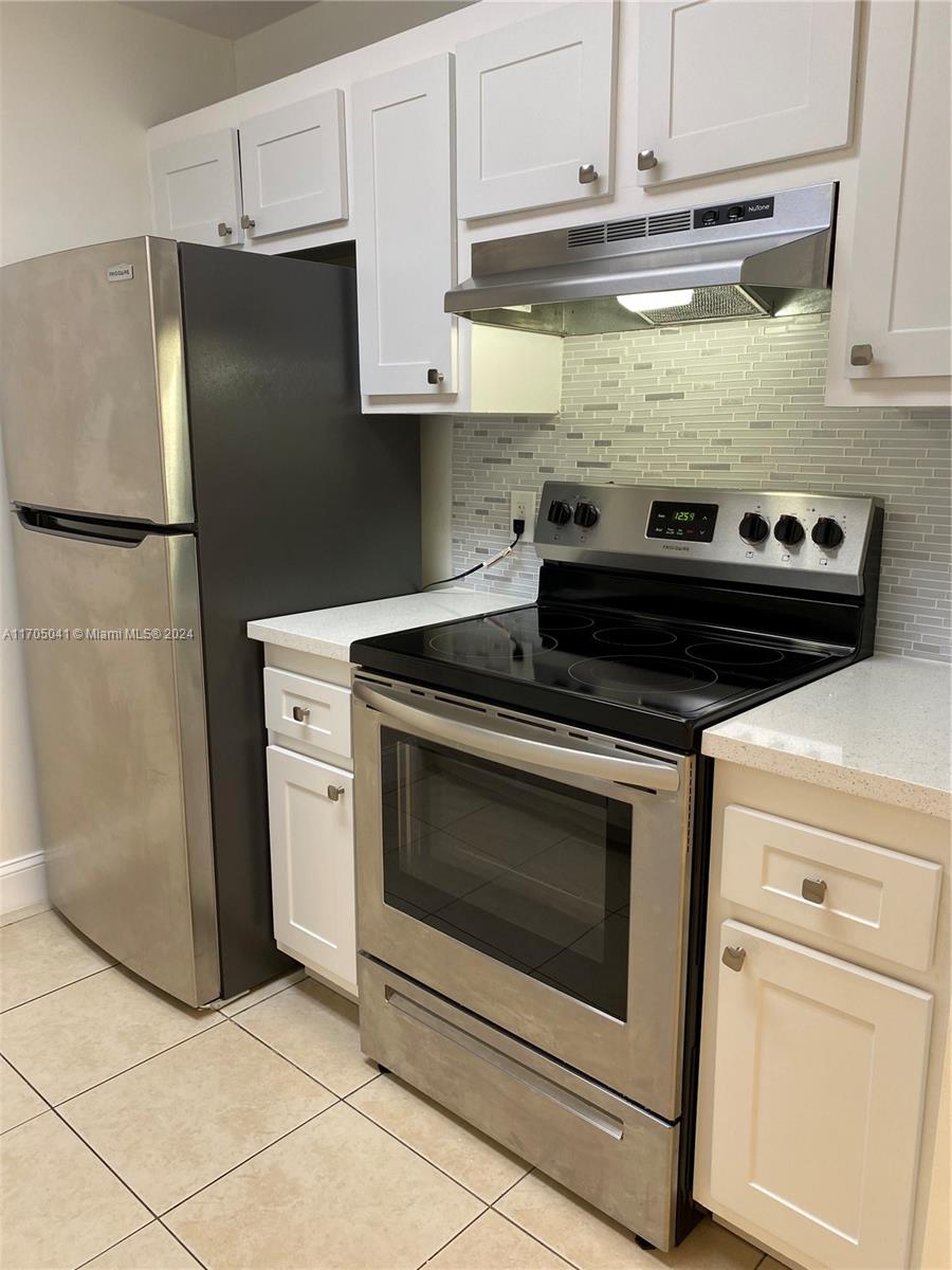 a stove top oven sitting inside of a kitchen