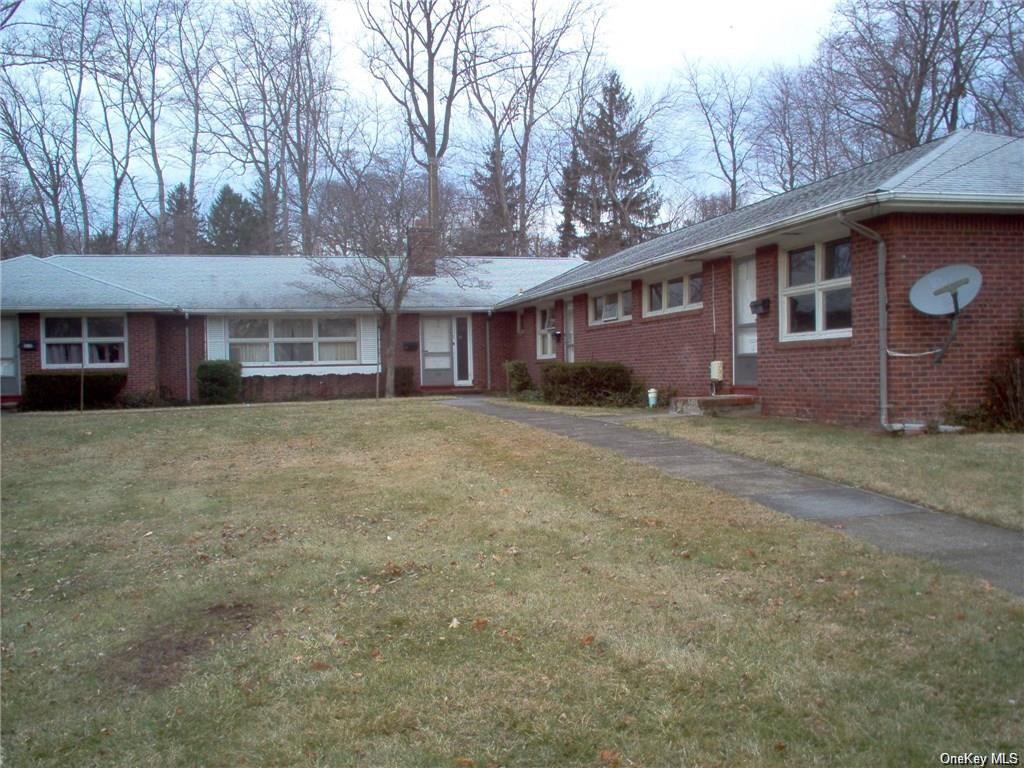 a front view of a house with a yard and trees