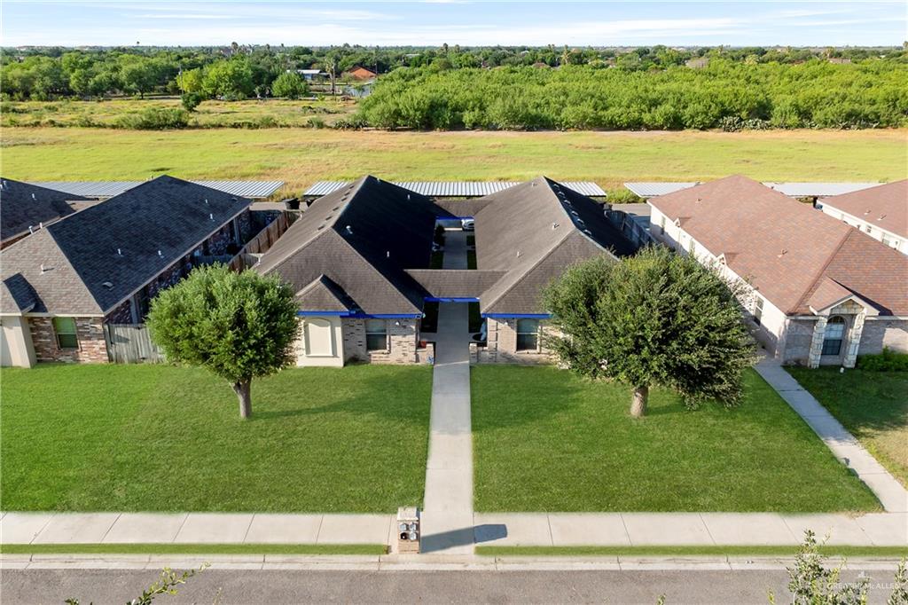 a view of a house with big yard and a lawn chair under an umbrella